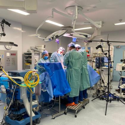 Surgeons conducting surgery with documentary crew filming
