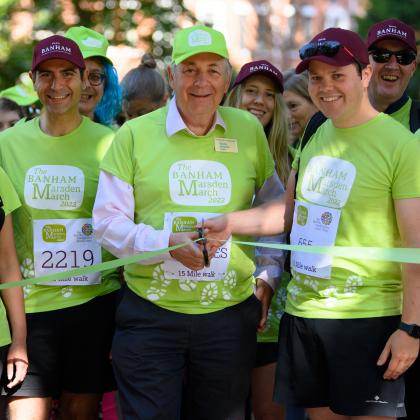 Charles Hallatt and team Banham at the start line of the Banham Marsden March in 2022. They are wearing green charity branded shirts and smiling 