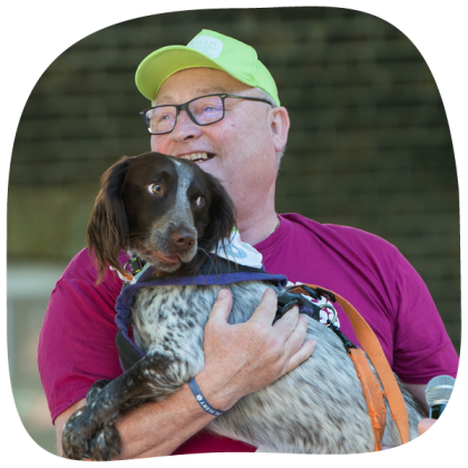 Banham Marsden March walker Malcom in a magenta t-shirt holding his dog patch