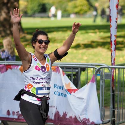 Patient and runner Klodjana Aliaj smiles and waves at the camera during the Royal Parks Half Marathon 2022