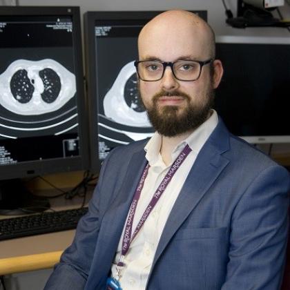 Dr Hunter sitting in front of a computer with scans on the screen