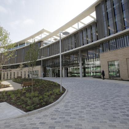 The outside of the Oak Cancer Centre on a sunny day - a brand new building with floor to ceiling windows and steel columns