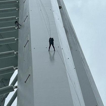 a small figure of someone abseiling down a rope on a large white structure