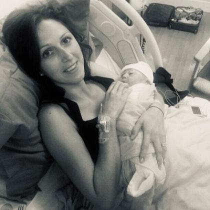 A woman in a hospital bed holding her newborn baby