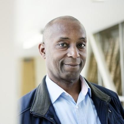 Professional headshot of a man wearing a shirt and jacket