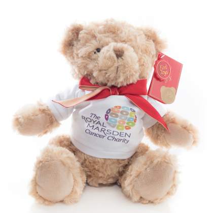 A fluffy teddy bear with a Royal Marsden Cancer Charity t shirt on and a red bow