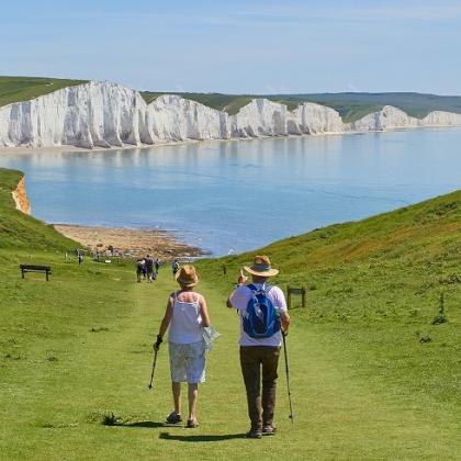 A couple hiking on the South Downs. The Seven sisters cliffs are in the background