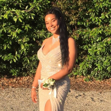 Courtney outside and smiling, wearing a gorgeous white, sparkly prom dress smiling