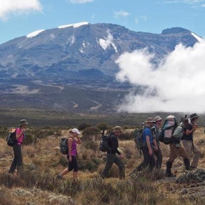 Several trekkers walking in front of a mountain