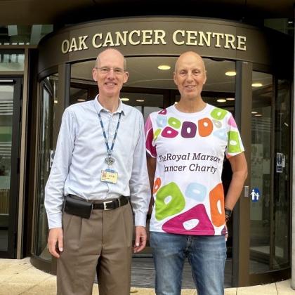 Kevin and Professor Chris Parker standing outside the front entrance to the Oak Cancer Centre. Kevin is wearing a Royal Marsden Cancer Charity t-shirt