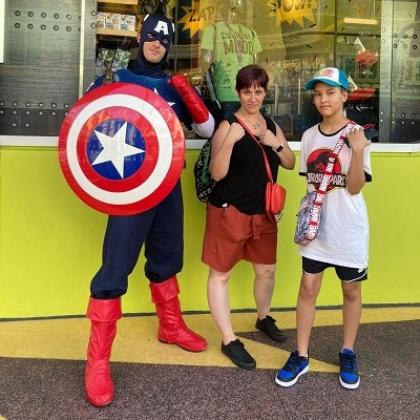 Roxanne with her young step son, they are standing next to marvel character Captain America at Disneyland and posing.