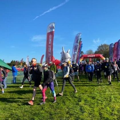 Several walkers on a grass field with the a 'Start' banner in the background