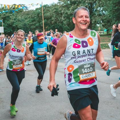 Two runners in charity vests at Royal Parks 2024