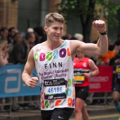 Team Marsden runner smiles at the camera and raises his fist
