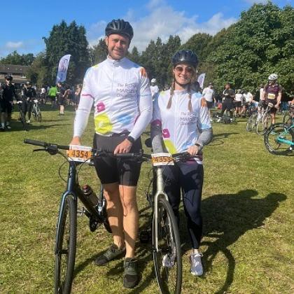 Two RMCC fundraisers at London to Brighton 2024, standing and smiling with their bikes