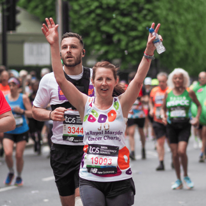 Jo with her hands up running the London Marathon 2024