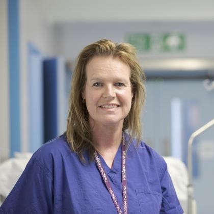 Headshot of Dr Marielle Nobbenhuis, standing in a corridor in The Royal Marsden. She has shoulder length, dark blonde hair, and is wearing dark blue scrubs.