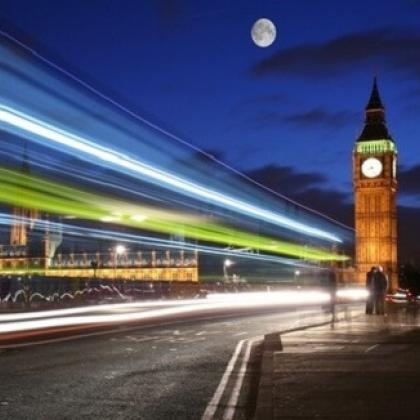 London at night with flashing lights and Big Ben and Houses of Parliament
