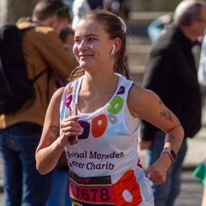 Royal Marsden runner running and smiling to the supporters in the crowd with airpods in.