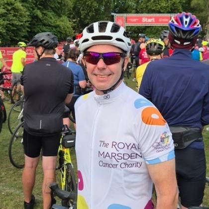 Team Marsden cyclist with bike helmet, smiling in cycling jersey 