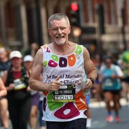 RMCC runner with the charity vest on smiling as he runs through the streets of London. 