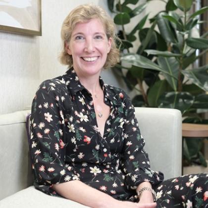 A lady in a black dress sitting smiling