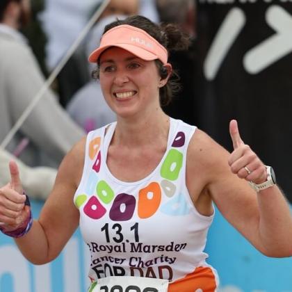 RMCC runner smiling with thumbs up to supporters as she finishes her run.