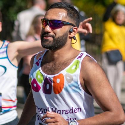 RMCC runner with sunglasses on running past supporters. 