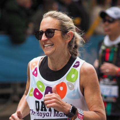RMCC runner smiling up close with sunglasses on with runners in the background. 