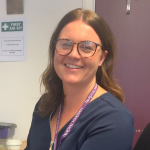 Sinead Golledge, sitting at her desk and smiling