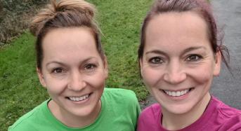 Two smiling women take a selfie in their Royal Marsden Running shirts. 