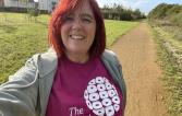 Jog 40 January runner, Katrina. She is smiling with her Royal Marsden Cancer Charity t-shirt on, while standing on a walking trail in a park.