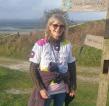 Supporter wearing a Royal Marsden Cancer Charity t-shirt standing by South Downs signpost