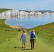 A couple hiking on the South Downs. The Seven sisters cliffs are in the background