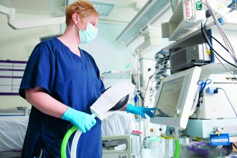 Nurse in a mask operating equipment