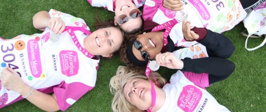 Marsden Marchers lie down on the grass with medals