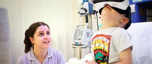 A young patient with a play specialist tries virtual reality glasses