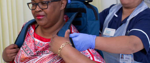Nurse helping patient with backpack