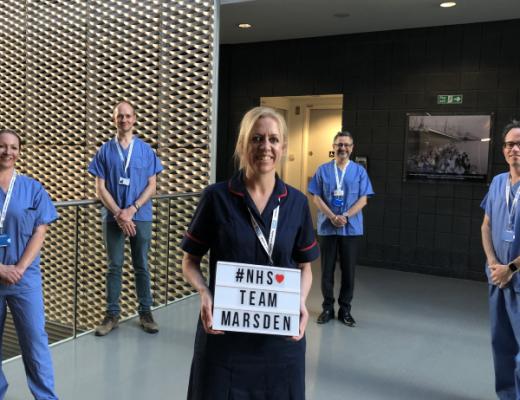 Staff standing in a group with a sign saying #NHS Team Marsden