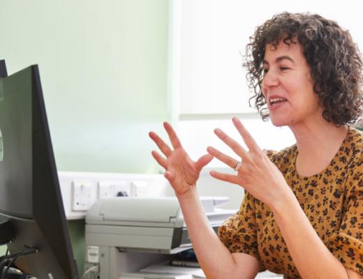 Doctor sat at desk on a virtual appointment on a computer