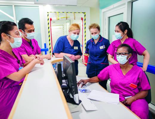 Team of CCU nurses at a desk, wearing masks