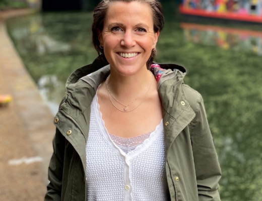 Katie Wilkins, standing by a canal, smiling at the camera