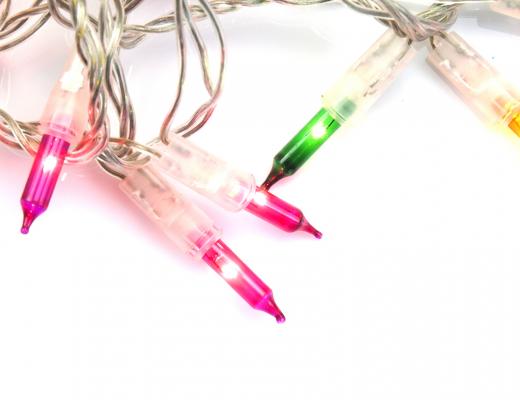 Colourful Christmas lights on white background - light up 2022