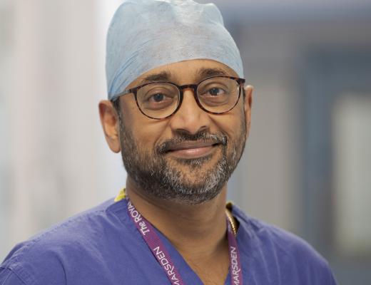 Professor Vinidh Paleri smiling, wearing blue scrubs and a Royal Marsden lanyard