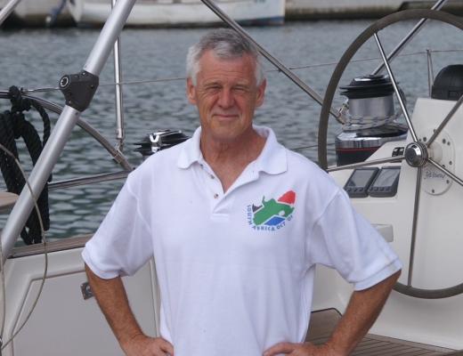 Michael Thick, on a sailing boat, wearing a white polo shirt