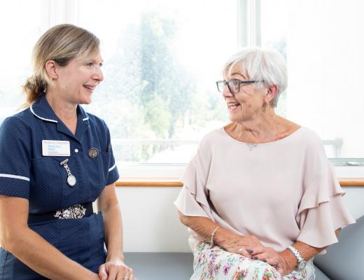 Jacky (right) speaking to a nurse (left) they a smiling