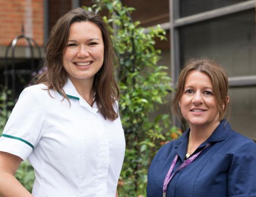 Two women outside the Royal Marsden Hospital. Both are smiling, have brunette hair and are wearing medical unforms
