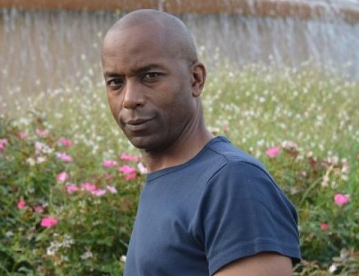 A man standing in a garden of wild flowers