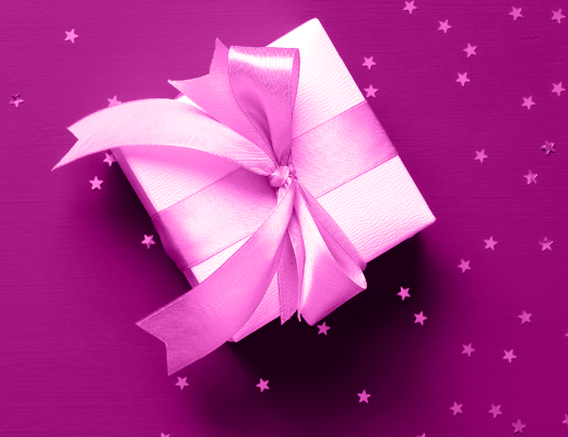 Pink Christmas present on a magenta background surrounded by small stars