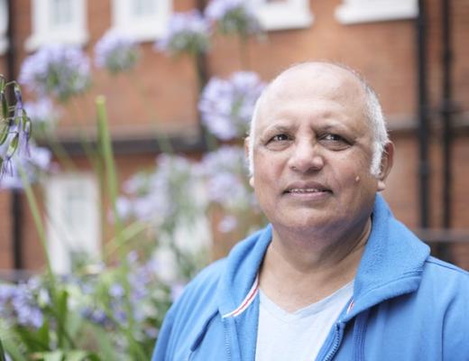 Headshot of Naz standing on a street wearing a blue hoodie and blue t-shirt